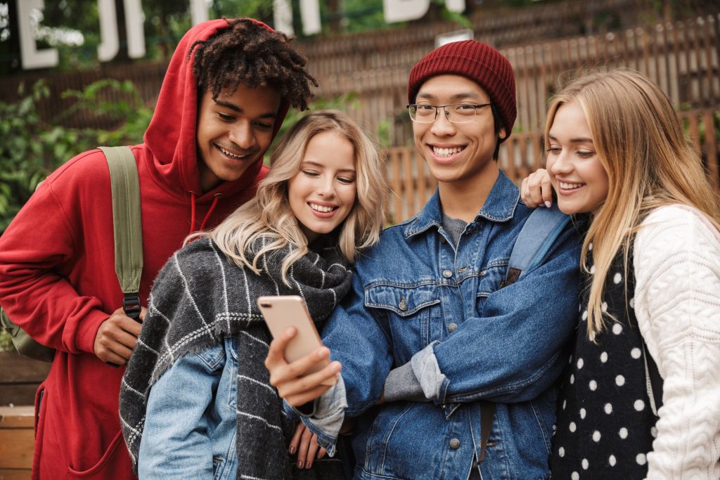 Group of happy teens looking at a phone